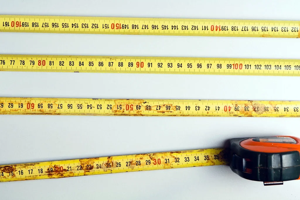 Measuring the width of a wooden floorboard with a tape measure