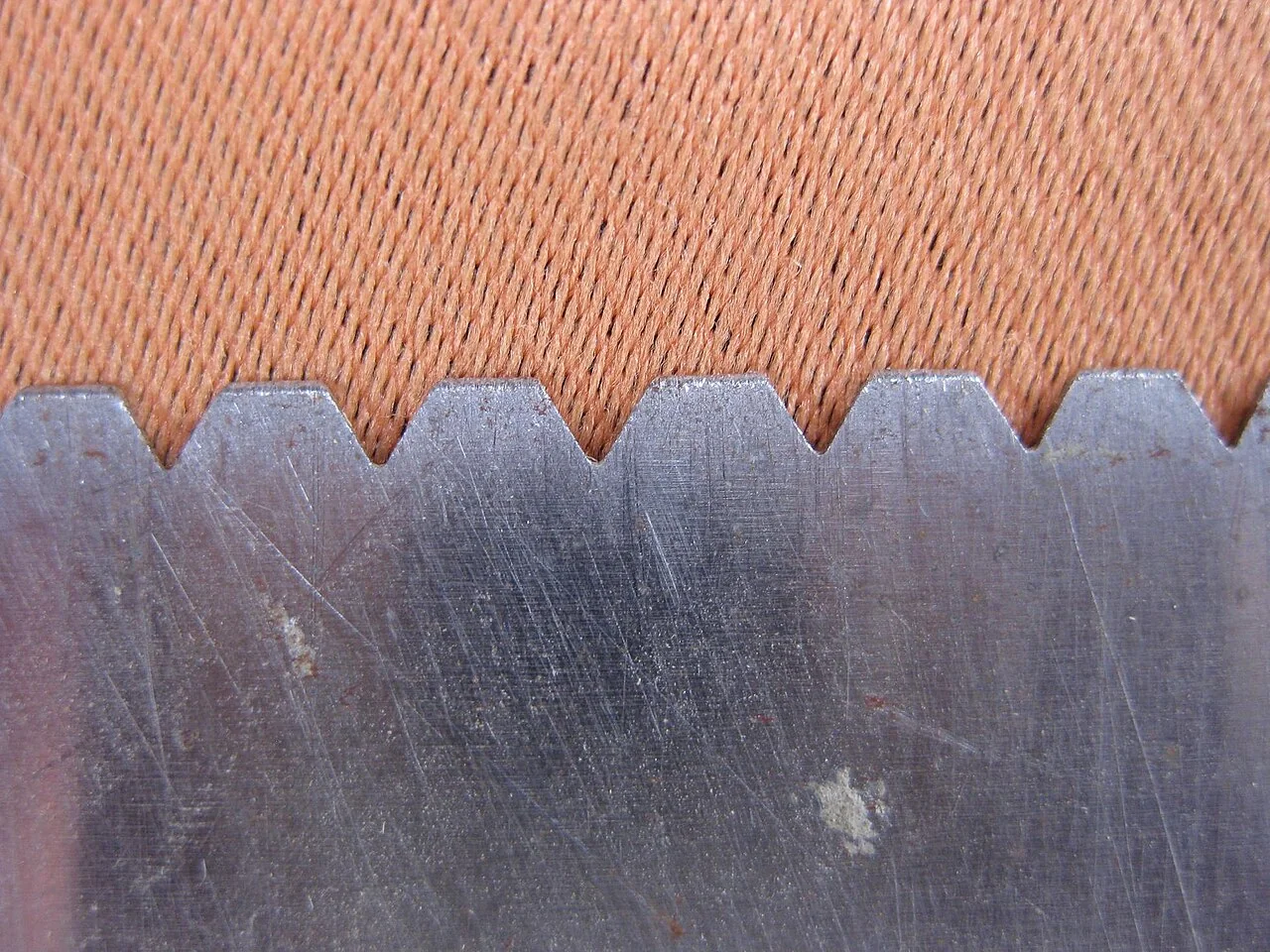 Glue for Vinyl Plank Flooring (2026): Which Bond Holds Which Board Close-up of notched spreader teeth that set adhesive ridge depth